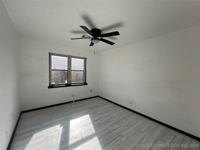 unfurnished room with ceiling fan, a textured ceiling, and light hardwood / wood-style flooring