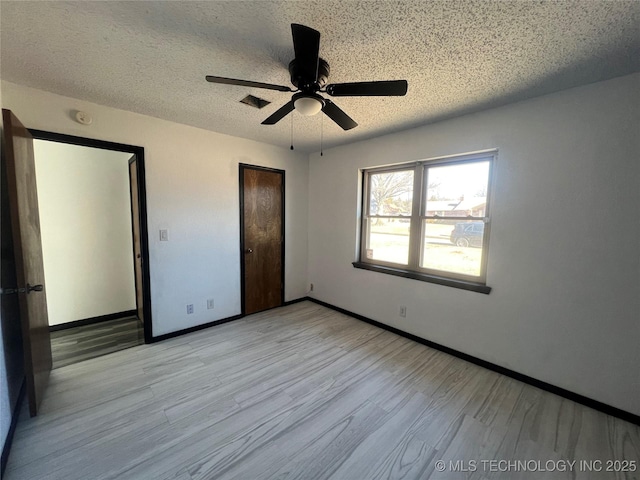 unfurnished bedroom with ceiling fan, a textured ceiling, and light hardwood / wood-style flooring