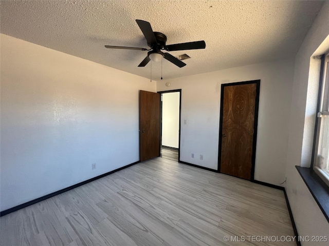 unfurnished bedroom with ceiling fan, a textured ceiling, and light hardwood / wood-style floors