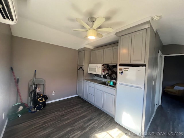 kitchen with lofted ceiling, ceiling fan, white appliances, gray cabinetry, and dark hardwood / wood-style flooring