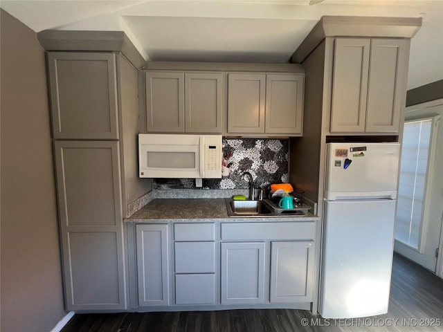 kitchen featuring white appliances, tasteful backsplash, sink, dark hardwood / wood-style floors, and gray cabinetry