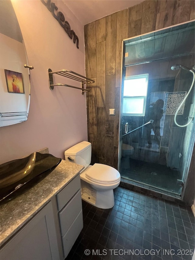 bathroom featuring a shower with door, tile patterned floors, toilet, and vanity