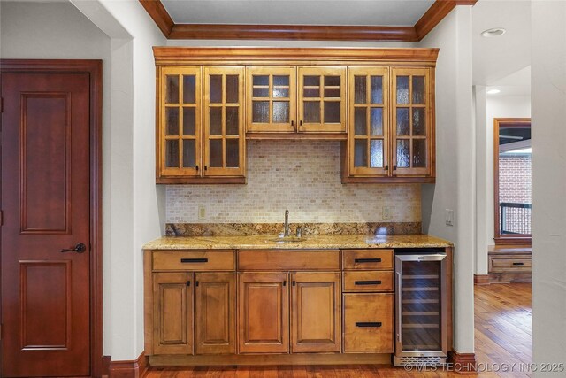 bar featuring light stone countertops, crown molding, wine cooler, and decorative backsplash