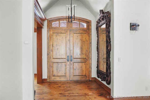 entryway with lofted ceiling and light wood-type flooring