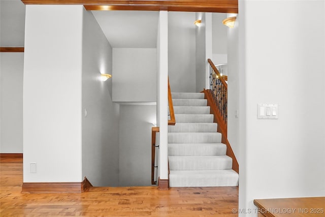 staircase with hardwood / wood-style floors