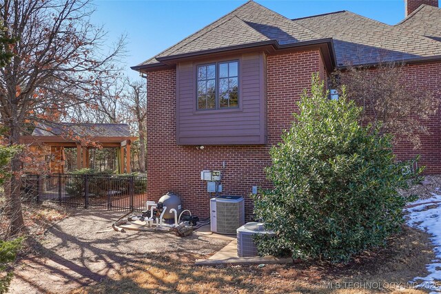 rear view of property featuring a patio and central air condition unit