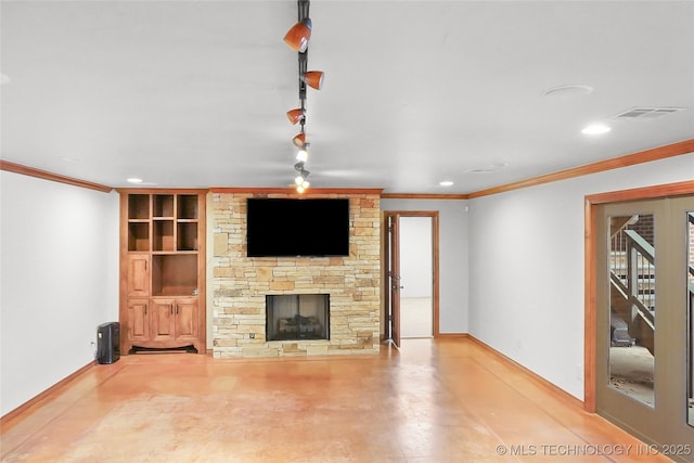 unfurnished living room featuring ornamental molding, built in features, track lighting, and a fireplace