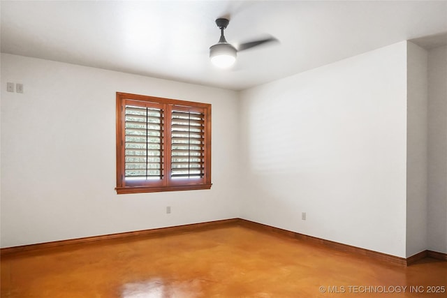 spare room with ceiling fan and concrete flooring