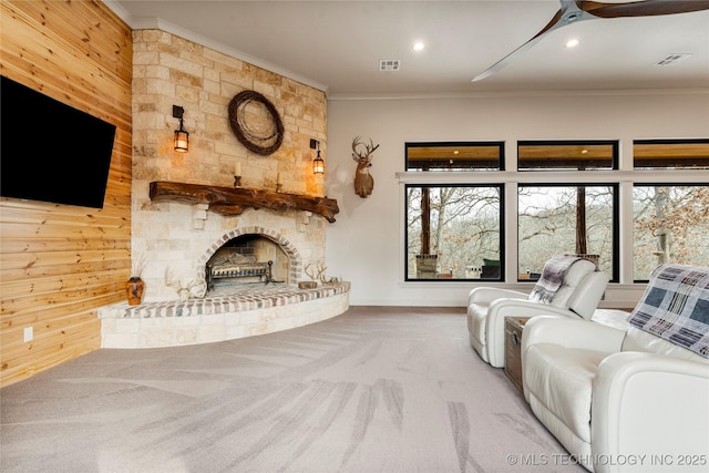 unfurnished living room featuring carpet floors, crown molding, wood walls, and a fireplace