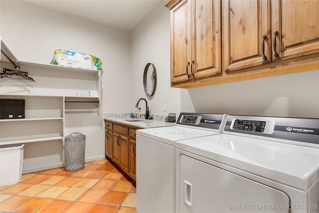 washroom with light tile patterned floors, washing machine and dryer, sink, and cabinets