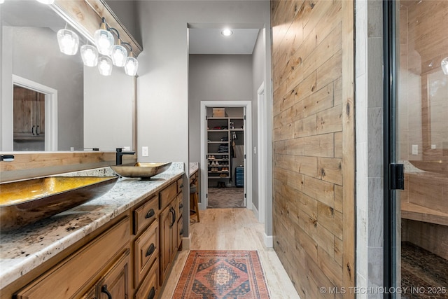 bathroom featuring a shower with door, wood-type flooring, and vanity