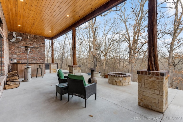 view of patio featuring exterior kitchen and an outdoor fire pit