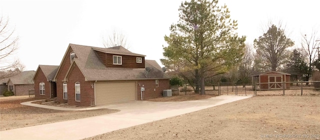 view of side of home with a shed, central AC unit, and a garage