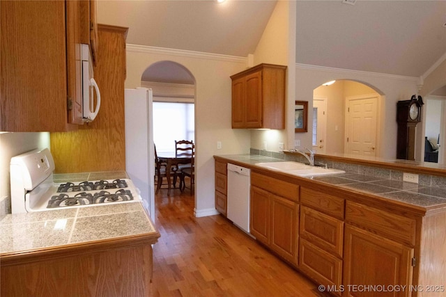 kitchen featuring sink, tile counters, kitchen peninsula, white appliances, and light hardwood / wood-style floors