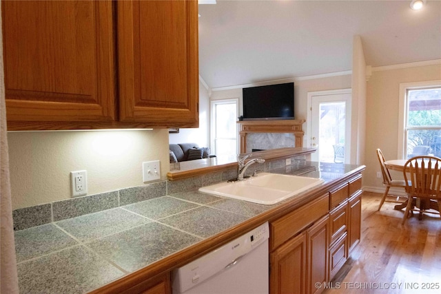 kitchen featuring ornamental molding, dishwasher, sink, and light hardwood / wood-style flooring