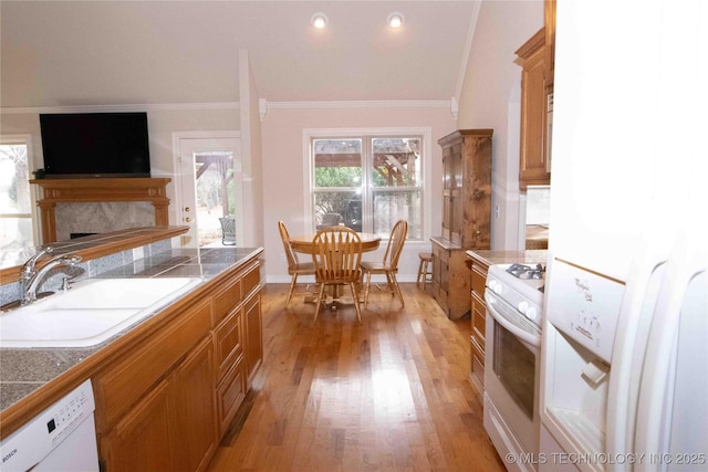 kitchen featuring crown molding, white appliances, sink, and light hardwood / wood-style flooring