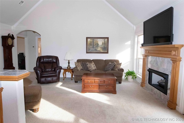 carpeted living room featuring ornamental molding, a fireplace, and high vaulted ceiling