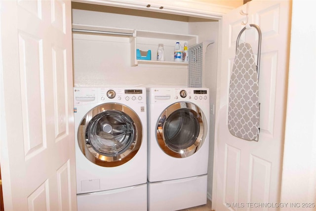 clothes washing area with washing machine and dryer