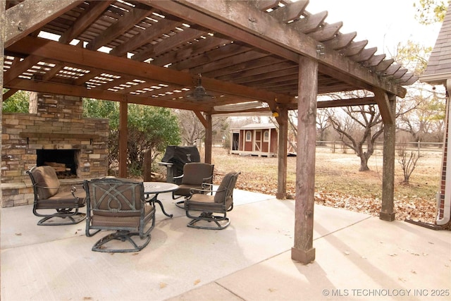 view of patio with a storage unit, a pergola, a grill, and an outdoor stone fireplace