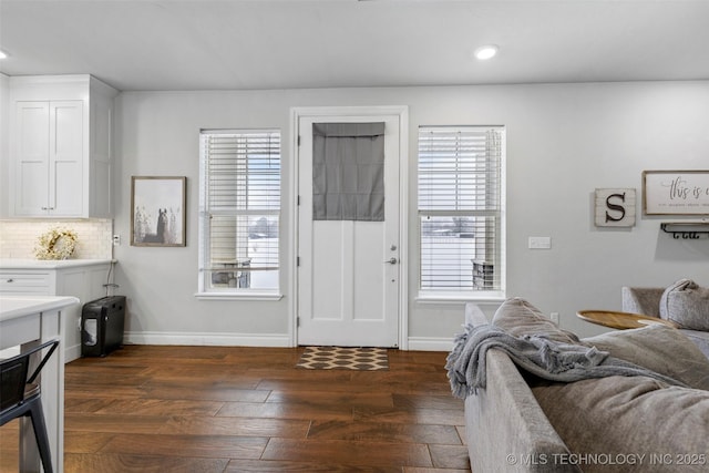 living room with plenty of natural light and dark hardwood / wood-style flooring