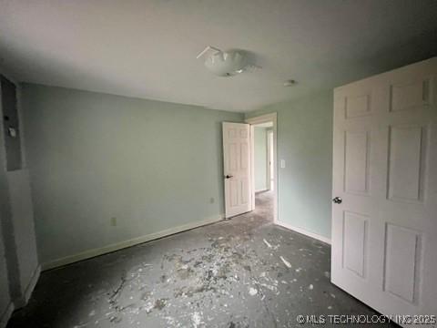 unfurnished bedroom with concrete flooring