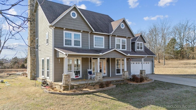 craftsman-style house featuring covered porch, a garage, and a front lawn