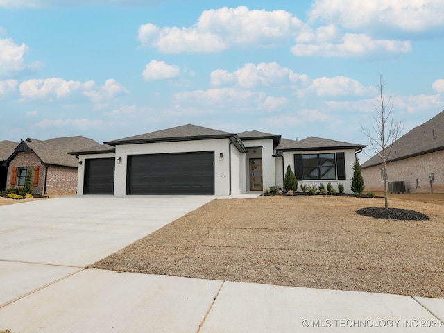 prairie-style home with concrete driveway, an attached garage, and central AC unit