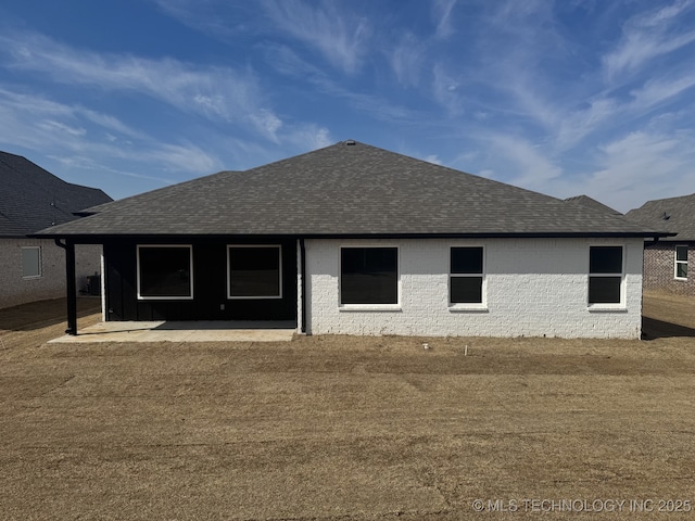 back of property featuring a patio and roof with shingles