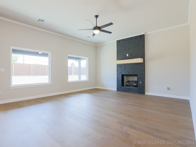 unfurnished living room with crown molding, a healthy amount of sunlight, a ceiling fan, and visible vents