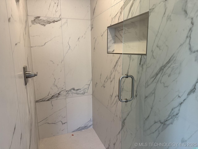 bathroom featuring a marble finish shower