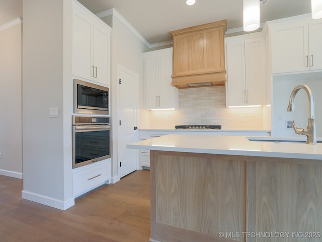 kitchen with oven, a sink, black electric cooktop, built in microwave, and ornamental molding