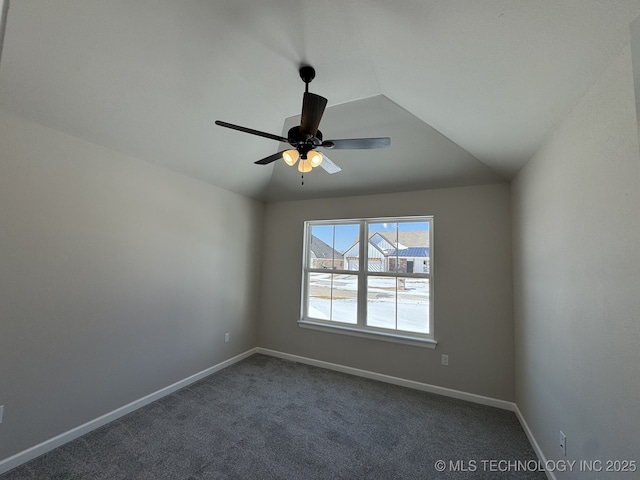 unfurnished room featuring vaulted ceiling, dark carpet, a ceiling fan, and baseboards