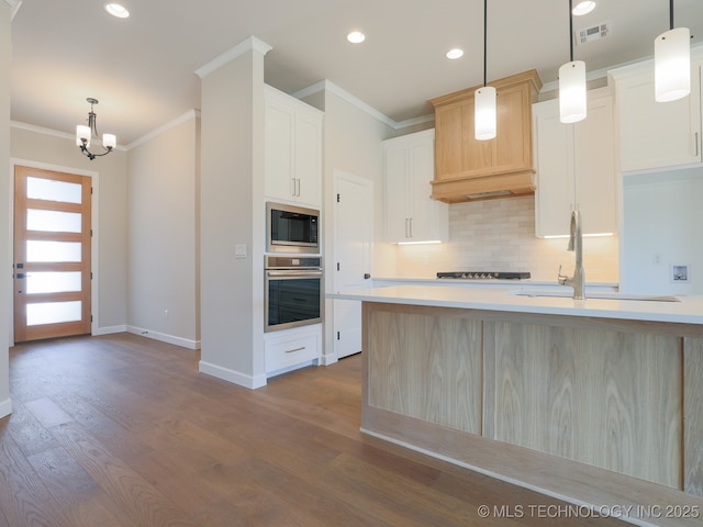 kitchen with visible vents, ornamental molding, oven, built in microwave, and tasteful backsplash