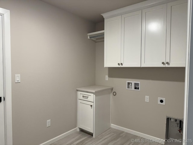 clothes washing area with hookup for a washing machine, cabinet space, light wood-style floors, hookup for an electric dryer, and baseboards