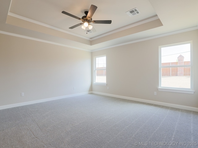spare room with crown molding, visible vents, carpet, and a raised ceiling