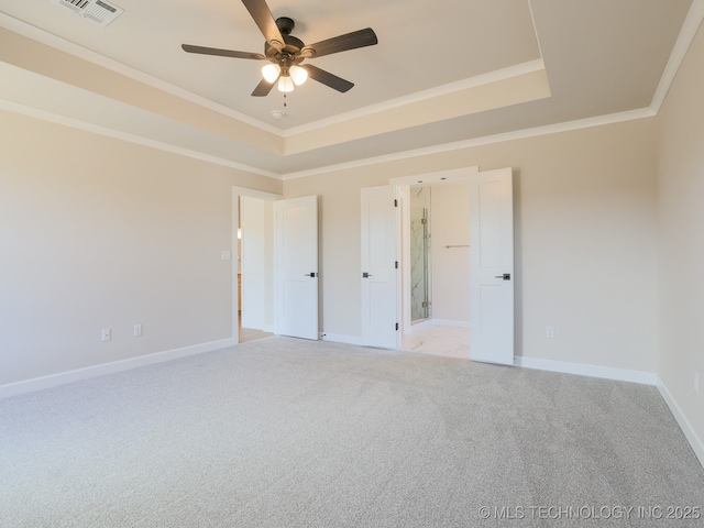 unfurnished bedroom with visible vents, ornamental molding, a tray ceiling, and light carpet