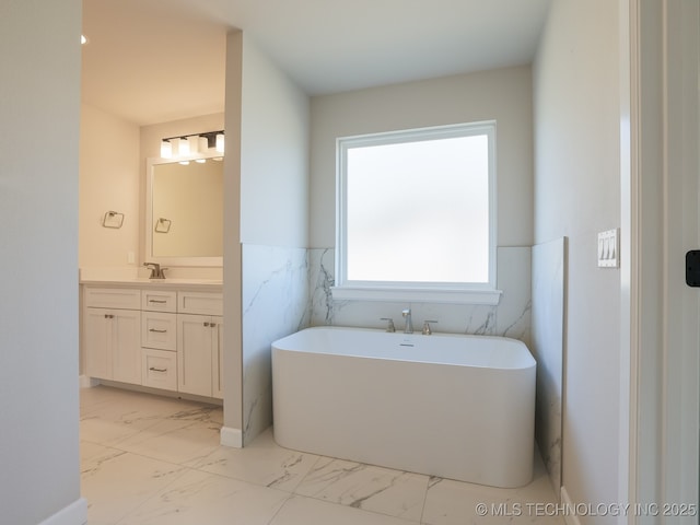 bathroom with a freestanding bath, wainscoting, marble finish floor, and vanity