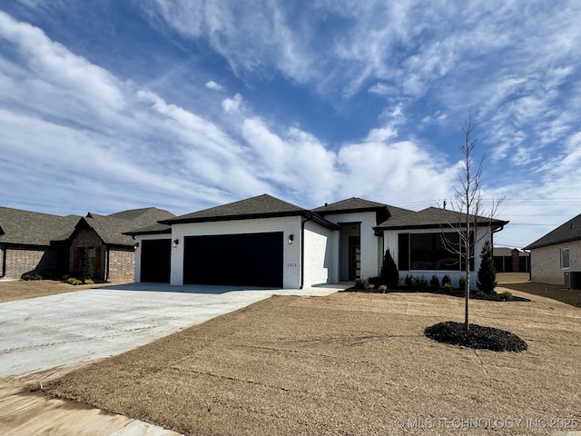 view of front of house with a garage, cooling unit, and concrete driveway