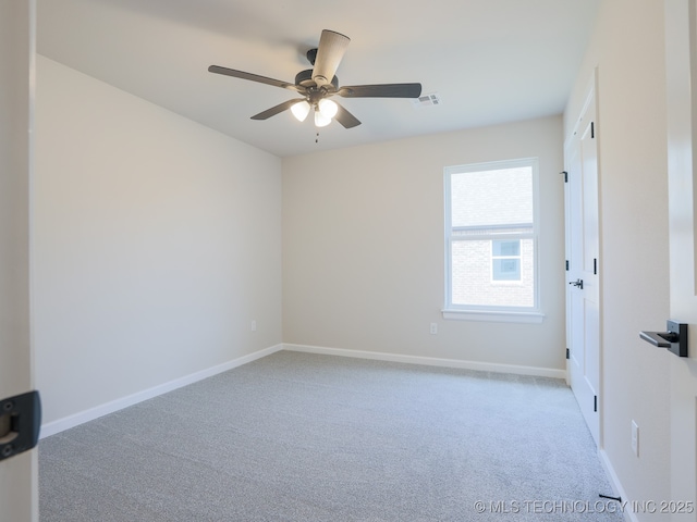 spare room with visible vents, a ceiling fan, carpet, and baseboards