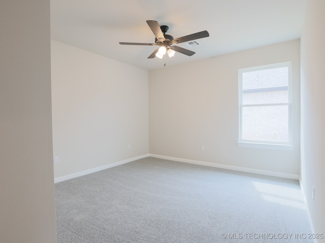 carpeted empty room featuring visible vents, a ceiling fan, and baseboards