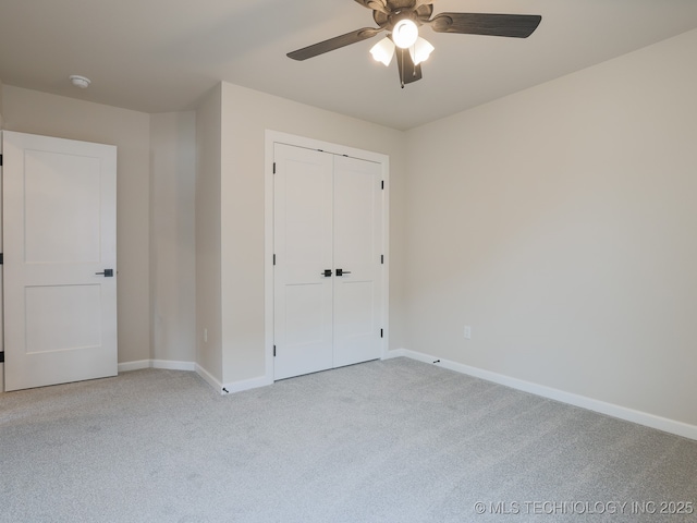unfurnished bedroom with a ceiling fan, baseboards, carpet, and a closet