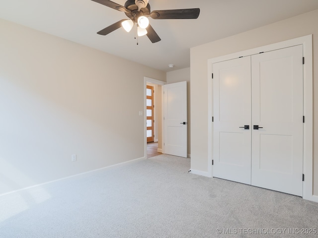 unfurnished bedroom with light colored carpet, a ceiling fan, baseboards, and a closet