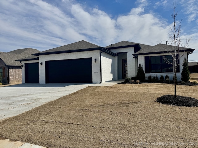 view of front of house with brick siding, driveway, a shingled roof, and a garage
