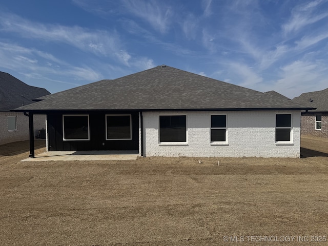 back of house with a patio and roof with shingles