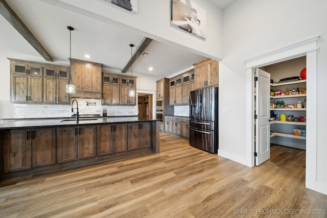 kitchen featuring stainless steel fridge with ice dispenser, beamed ceiling, backsplash, pendant lighting, and sink