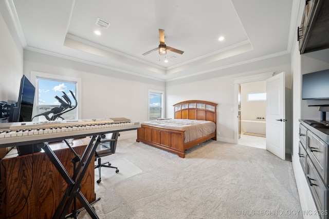 carpeted bedroom with multiple windows, a tray ceiling, and crown molding