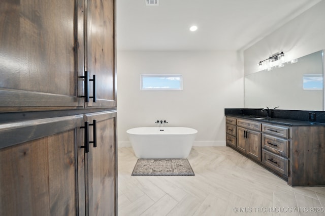 bathroom with a washtub and vanity