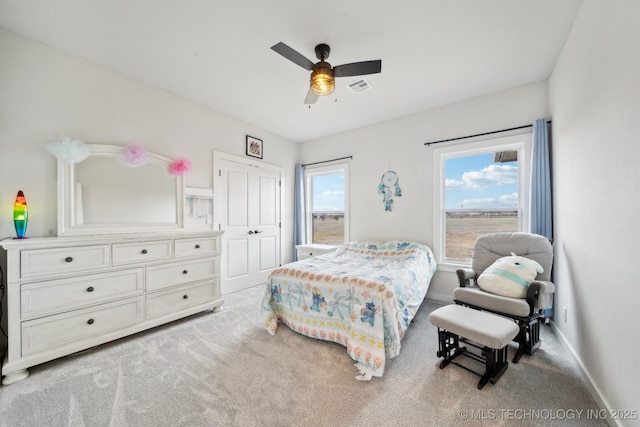 carpeted bedroom featuring ceiling fan and a closet