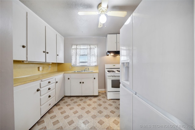 kitchen featuring white appliances, white cabinets, a textured ceiling, sink, and ceiling fan