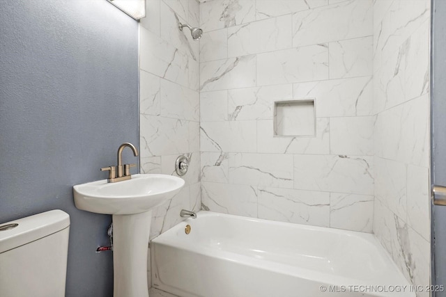 bathroom with toilet and tiled shower / bath combo